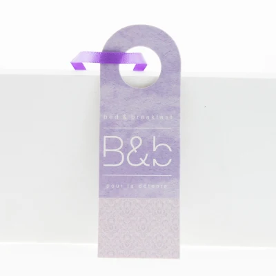Cartellino viola per indumento piegato con logo personalizzato in cartone UV con nastro